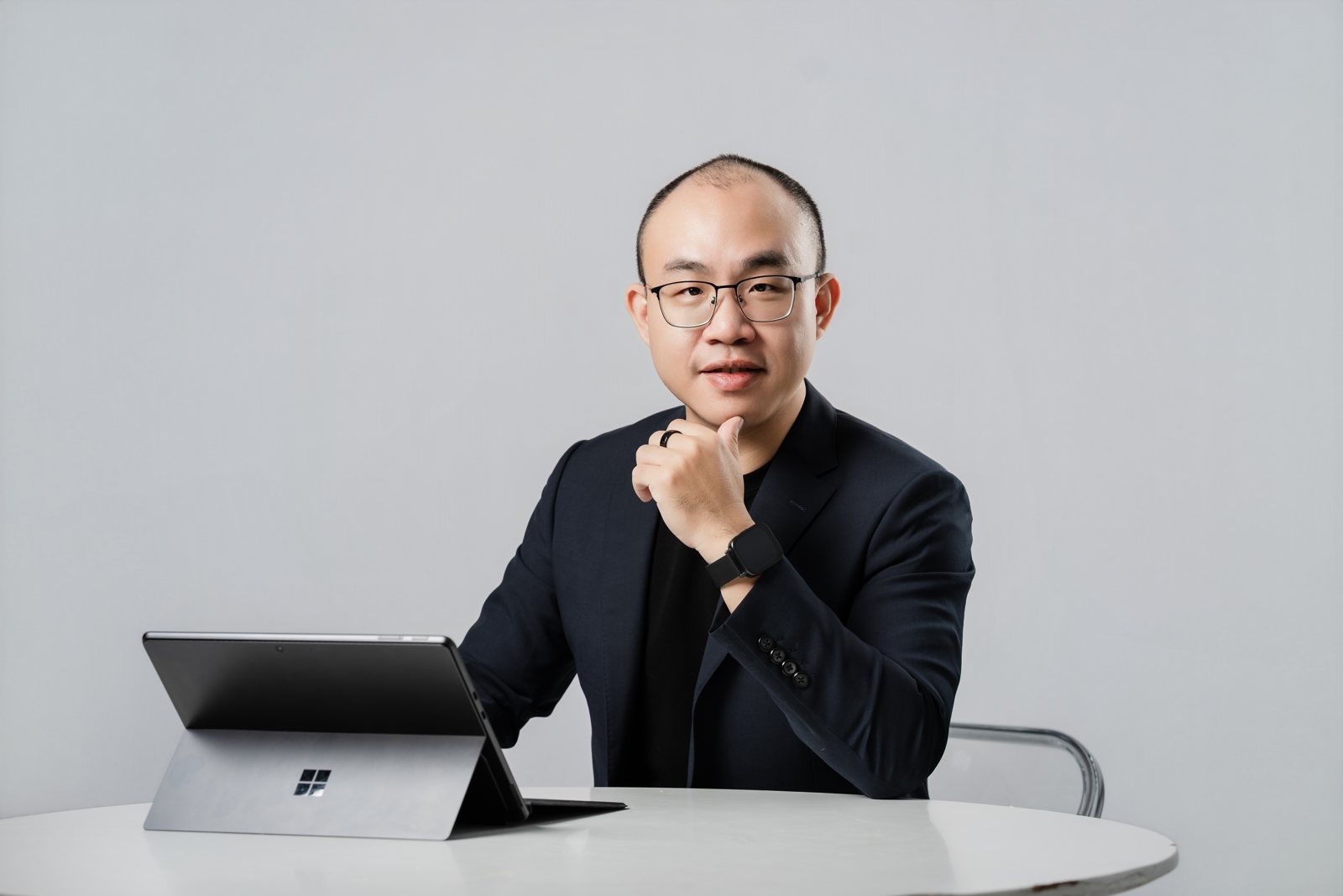 林昱任坐在桌前，手托下巴，桌上放著筆電
