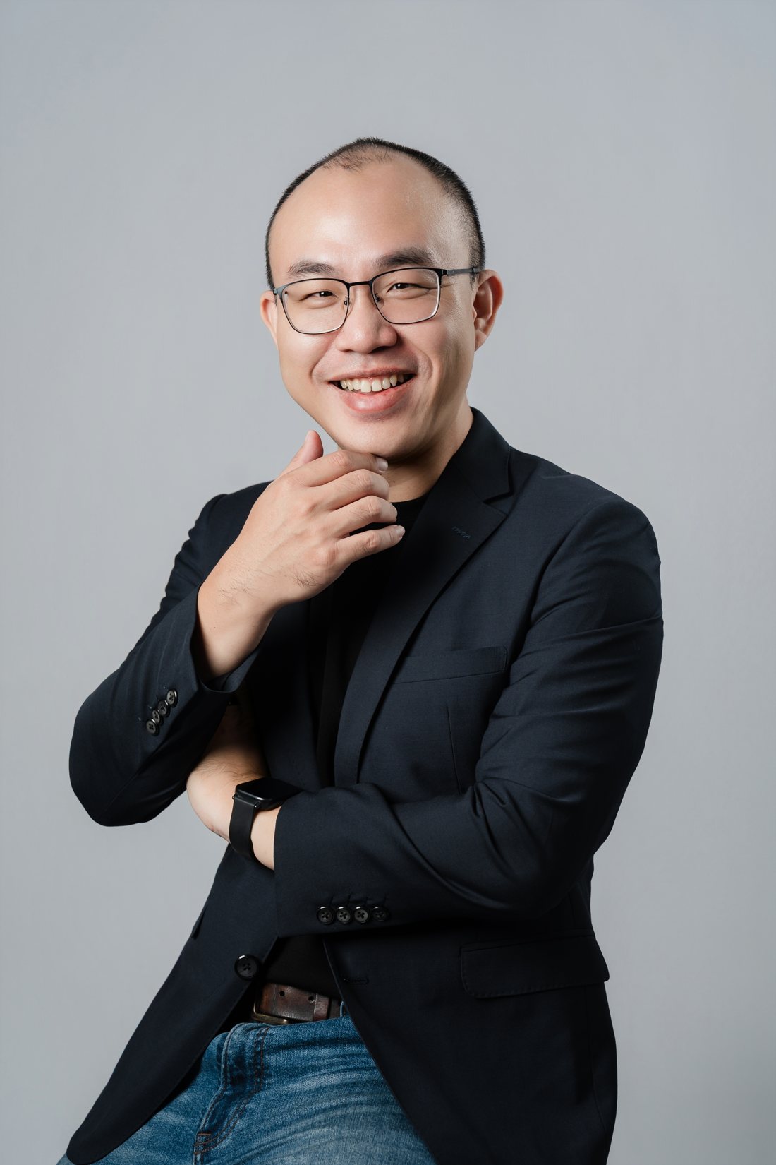 林昱任，穿深色西裝外套，手托下巴微笑